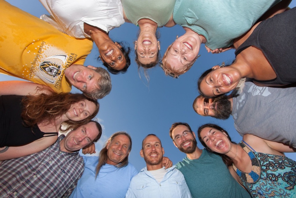 Faces in a circle from the ground up with blue sky