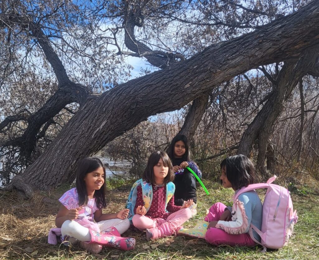 Kids meditating together under a tree at Polestar summer camp
