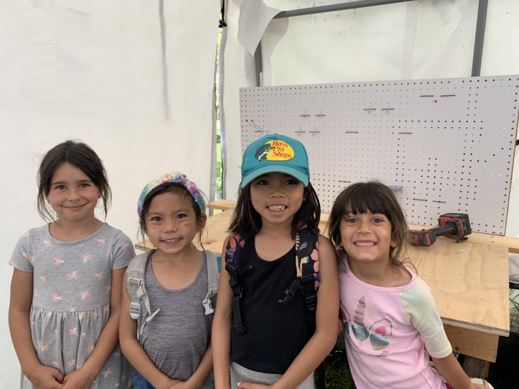 Girls proudly standing in front of the tool organizer they built