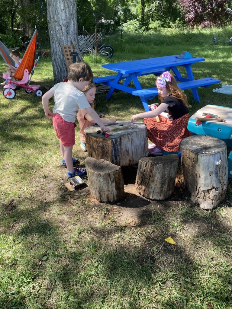 Kids practice basic carpentry skills on tree stump
